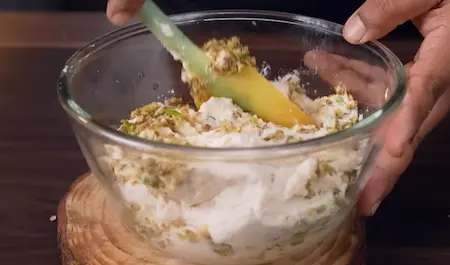 Whisking urad dal batter until light and fluffy for Udid Daliche Vade recipe