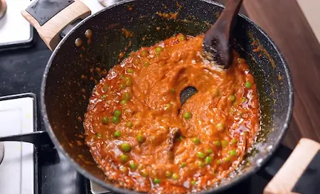 Step 5: cooking tomato puree and green peas for Suran ki Sabji Recipe
