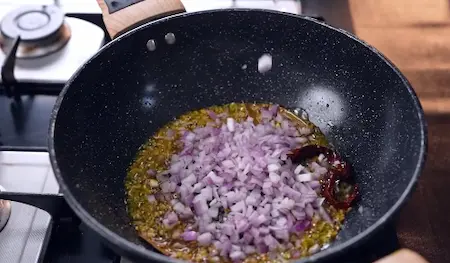 Step 3: sautéing garlic ginger chilli and onion for Papad ki Sabji Recipe