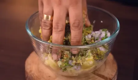 Step 4: Making Aloo Chokha by mashing boiled potatoes with thecha and mustard oil