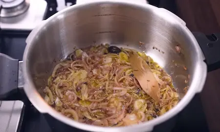 Step 4: Sautéing sliced onions to golden brown for Mushroom Masala base