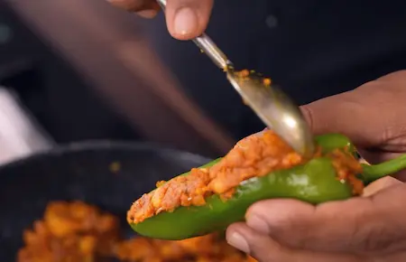 Step 4: Stuffing achari green chillies with aloo mixture for Sindhi Dahi Mirchi Chaat