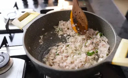 Cooking onion and spices in oil for Spicy Aloo Sabji