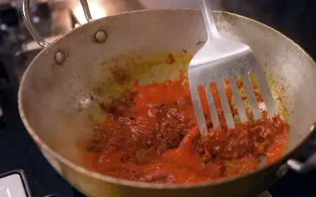 Adding tomato puree to the Aloo Chana Sabzi