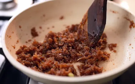 Cooking jaggery and coconut for stuffing