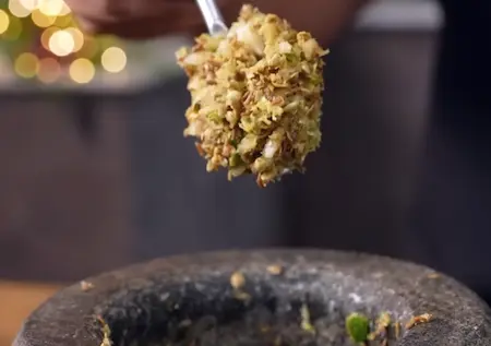 Preparing crushed spice mixture with coriander seeds, jeera, chilli, ginger, and garlic for Udid Daliche Vade recipe