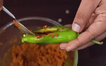 Step 2: Stuffing Bhavnagri chillies with achari masala mixture for Achari Dal