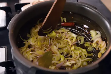 Golden brown onions being sautéed in a pan