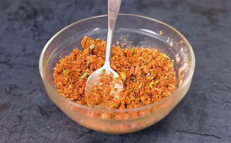 Preparing stuffing for Kathiyawadi Baingan with spices and herbs