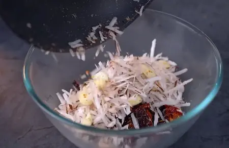 Roasting ingredients for gassi paste with coconut and spices.