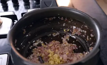 Preparing dal base with onions and tomatoes in pan