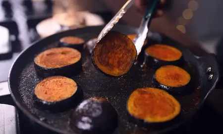 Step 2: Pan-searing marinated baingan slices until golden for Dahi Baingan recipe