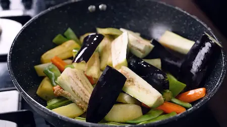 Step 4: Adding drumstick, brinjal, papdi and kaddu to the pan for Bengali Niramish Jhol