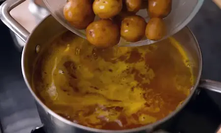 Boiling baby potatoes with turmeric and salt