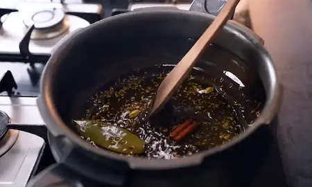 Heating oil and tempering spices in a kadhai