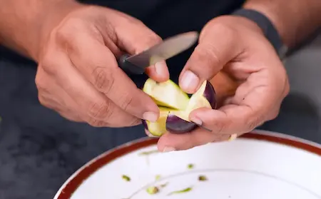 Preparing brinjal by cutting slits for stuffing