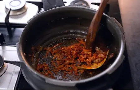 Adding ginger garlic paste and spices to the onions