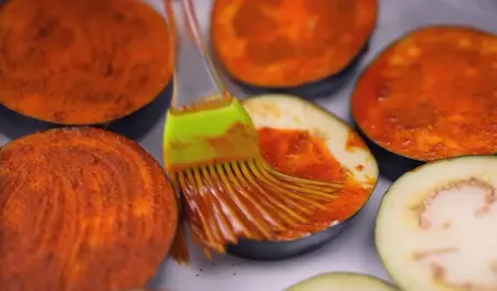 Step 1: Marinating baingan slices with turmeric and red chilli powder for Smoky Aloo Chokha + Creamy Dahi Baingan