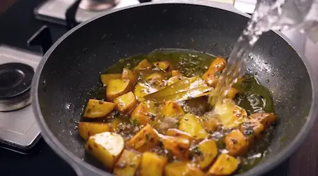 Step 3: Adding kasoori methi, dry ginger powder and salt to potatoes for Aligarh Kachori Aloo Sabzi