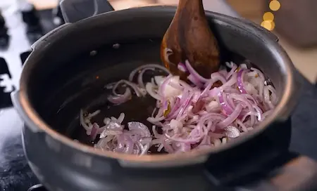 Sautéing onions in ghee until golden brown