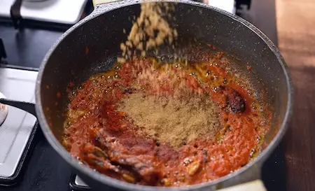 Roasting dry spices in masala for dum aloo in Aloo Dum Muri Ghugni